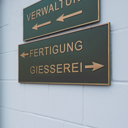 Bronze Wegweiser an Wand