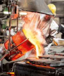 Arbeiter in Sicherheitskleidung giesst Metal