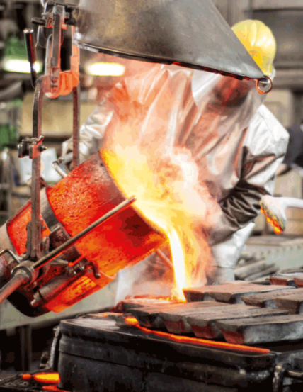 Arbeiter in Sicherheitskleidung giesst Metal