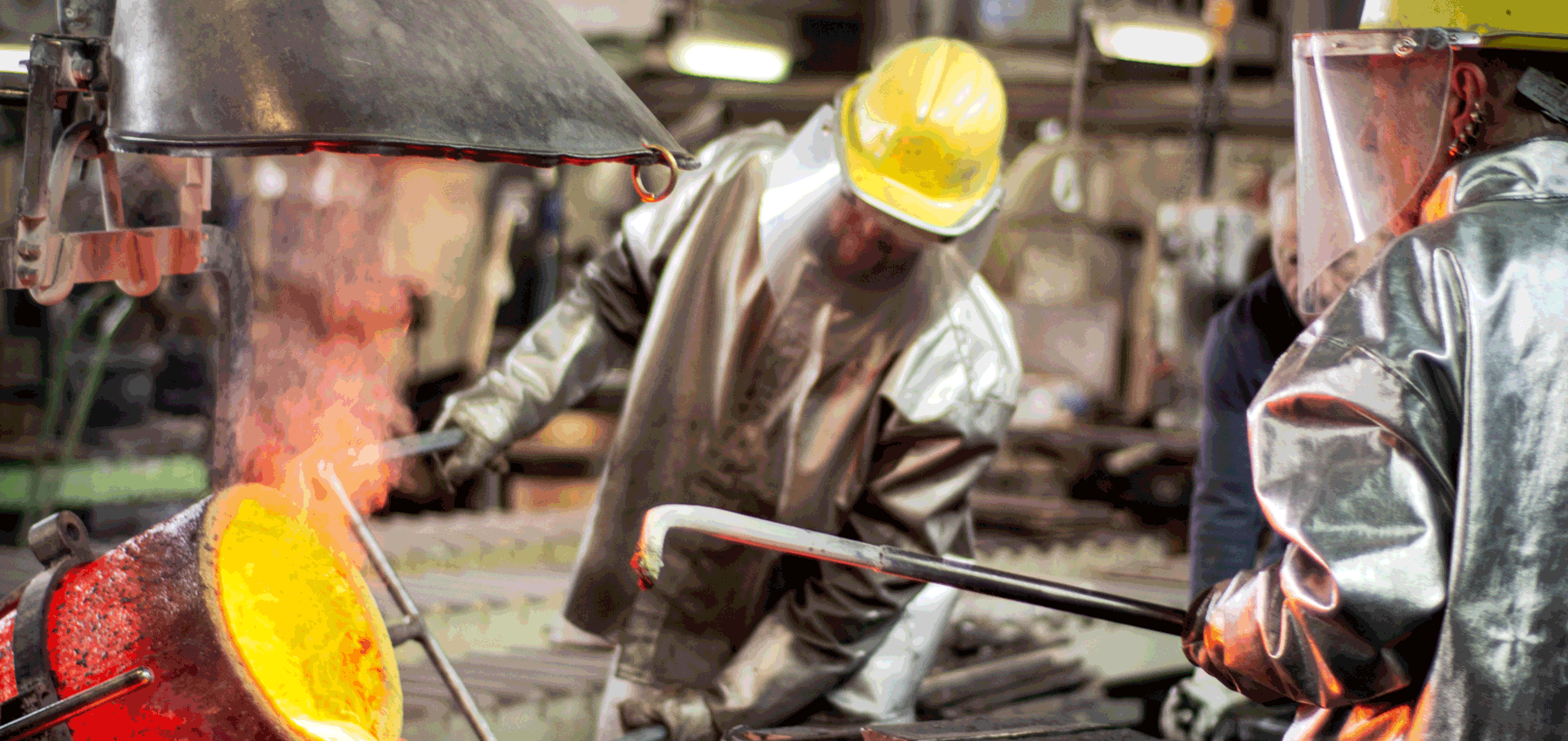 Zwei Arbeiter in Sicherheitskleidung giessen Metal