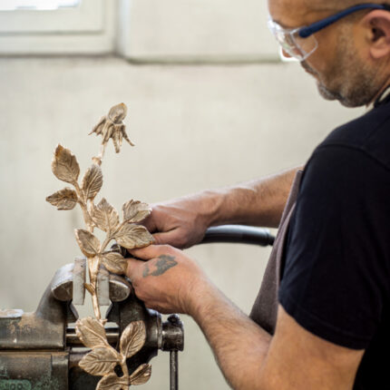 Mann bei Ziselierung von Blumenfigur